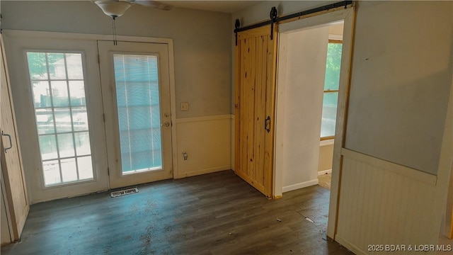 26587 Lake Front Ln, Rocky Mount, MO 65072 - doorway to outside featuring dark wood-style flooring, a ceiling fan, a barn door, and wainscoting