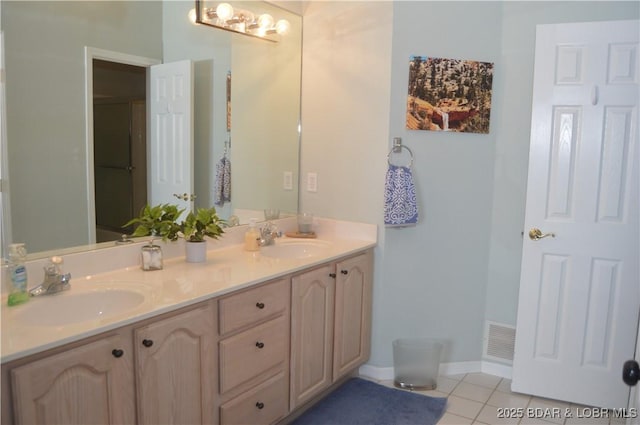 full bath with tile patterned floors, double vanity, and baseboards
