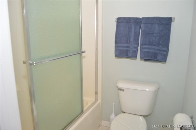 full bath featuring toilet, bath / shower combo with glass door, and baseboards