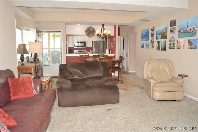 carpeted living room featuring a chandelier and baseboards
