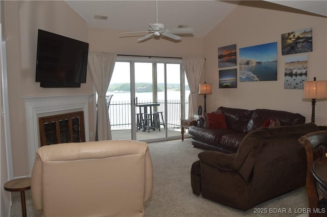 living room with carpet floors, a ceiling fan, lofted ceiling, and a glass covered fireplace