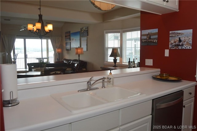 kitchen with dishwasher, a sink, a chandelier, light countertops, and decorative light fixtures