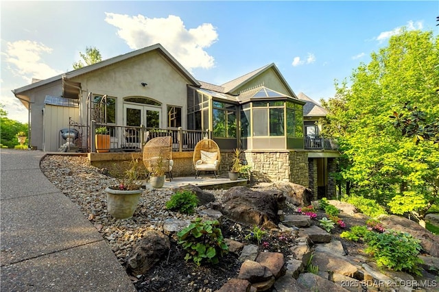 126 W Cross Fox Trl, Camdenton, MO 65020 - view of front of house featuring stone siding, stucco siding, and a sunroom