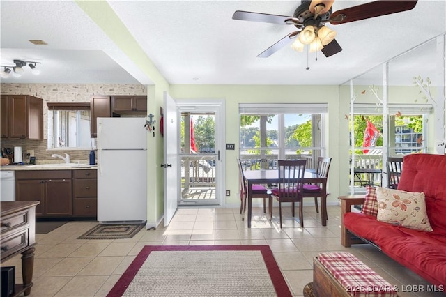 kitchen with white appliances, light tile patterned floors, light countertops, ceiling fan, and a sink
