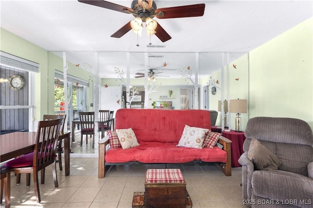 living area featuring a ceiling fan and tile patterned flooring