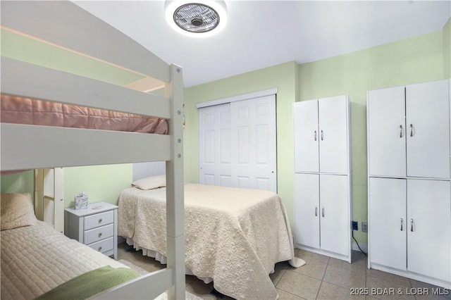 bedroom with tile patterned flooring and a closet