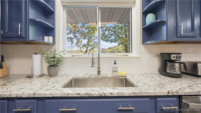 42 Buttercup Rd, Lake Ozark, MO 65049 - kitchen featuring blue cabinets, open shelves, a sink, and decorative backsplash