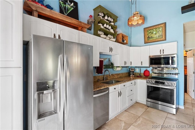 30566 Johnson Bay Dr, Gravois Mills, MO 65037 - kitchen with stainless steel appliances, a sink, white cabinets, light tile patterned floors, and dark stone countertops