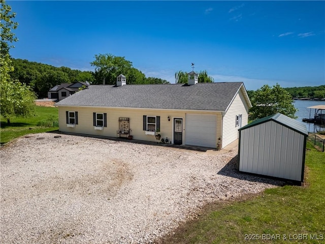 30566 Johnson Bay Dr, Gravois Mills, MO 65037 - rear view of house featuring an attached garage, driveway, a chimney, and a shingled roof
