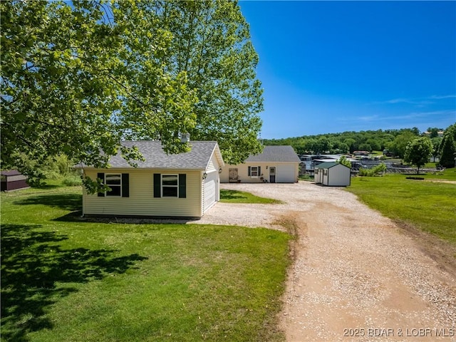 30566 Johnson Bay Dr, Gravois Mills, MO 65037 - bungalow featuring a front yard, an outdoor structure, dirt driveway, and roof with shingles