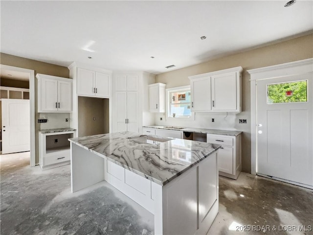 17 Eagles Pass, Climax Springs, MO 65324 - kitchen with concrete flooring, white cabinetry, a center island, and light stone countertops