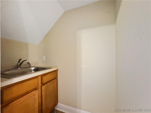 bar with a sink and vaulted ceiling