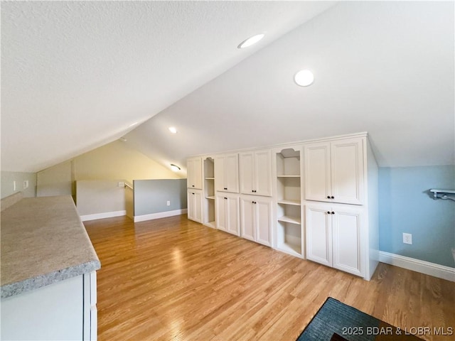 bonus room featuring lofted ceiling, light wood-type flooring, baseboards, and recessed lighting