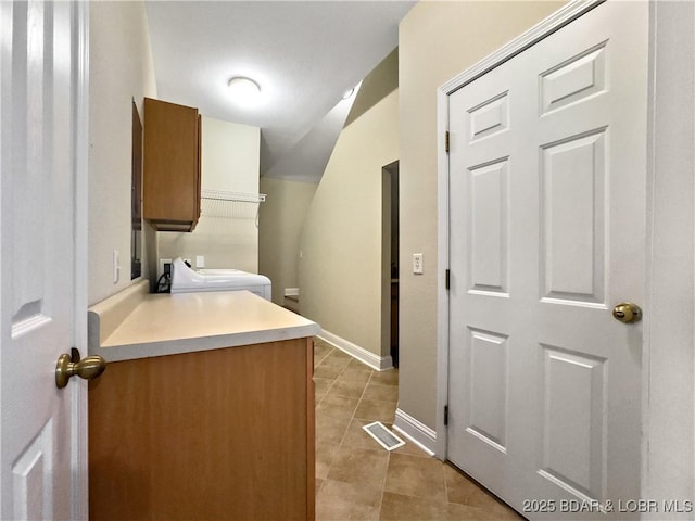 laundry room featuring cabinet space, light tile patterned flooring, baseboards, and washer / clothes dryer