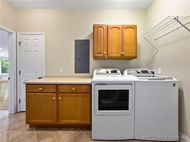 laundry room featuring electric panel, washer and dryer, cabinet space, and light tile patterned floors