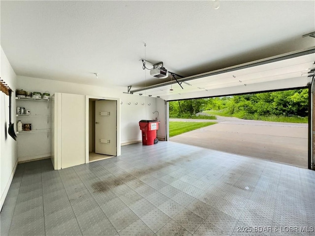 garage featuring a garage door opener and baseboards