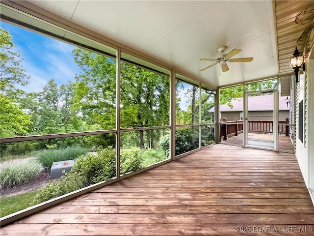 unfurnished sunroom with ceiling fan