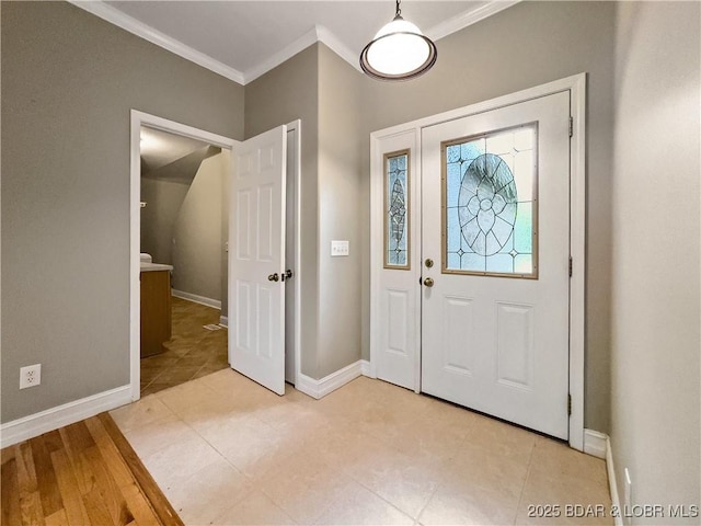 entryway with ornamental molding and baseboards