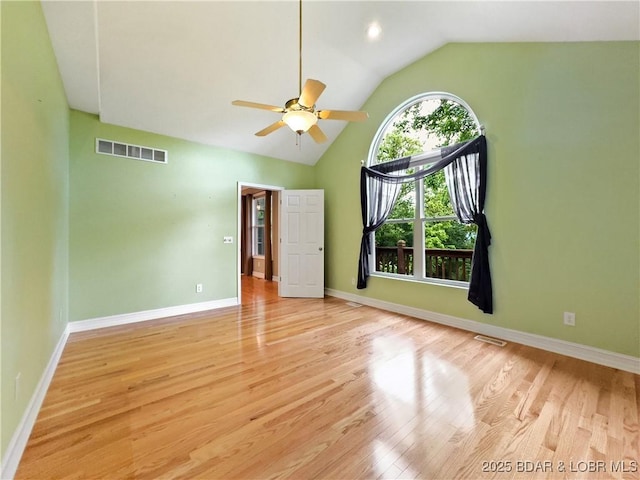 unfurnished room featuring wood finished floors, ceiling fan, baseboards, and high vaulted ceiling