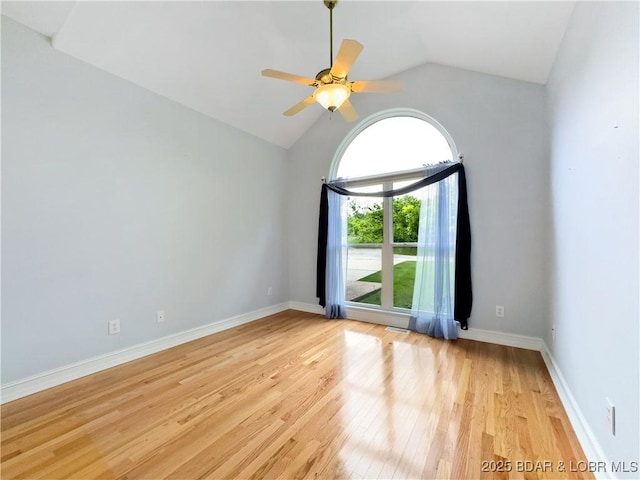 unfurnished room with lofted ceiling, light wood-style floors, a ceiling fan, and baseboards