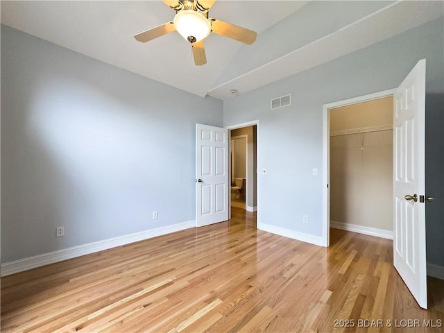 unfurnished bedroom with light wood-type flooring, baseboards, high vaulted ceiling, ceiling fan, and a closet