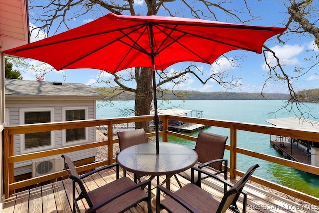 wooden terrace featuring a water view and outdoor dining space