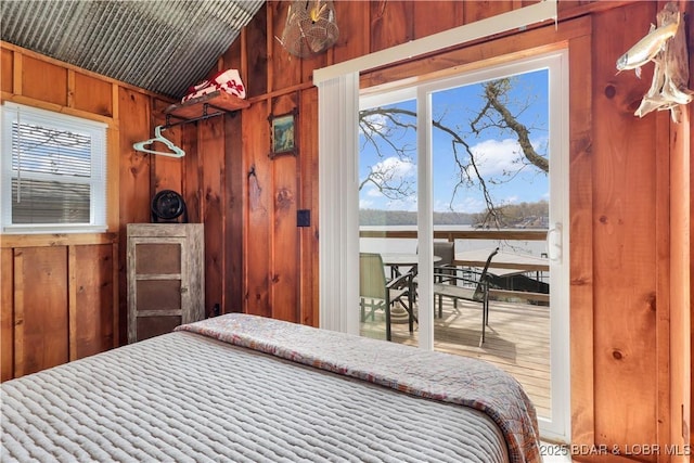 bedroom with access to outside and wooden walls