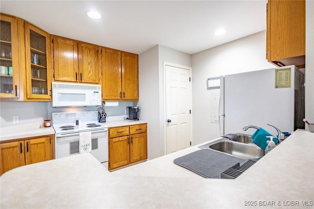 601 Park Place Dr Unit 2B, Kaiser, MO 65047 - kitchen featuring white appliances, a sink, light countertops, brown cabinetry, and recessed lighting