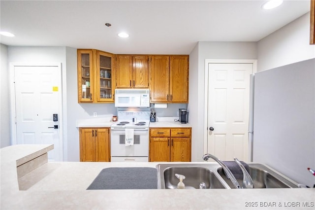 601 Park Place Dr Unit 2B, Kaiser, MO 65047 - kitchen featuring white appliances, a sink, brown cabinets, light countertops, and recessed lighting