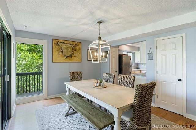 241 Shell Bay Cir Unit 1A, Linn Creek, MO 65052 - dining area with a textured ceiling, a chandelier, and light wood finished floors