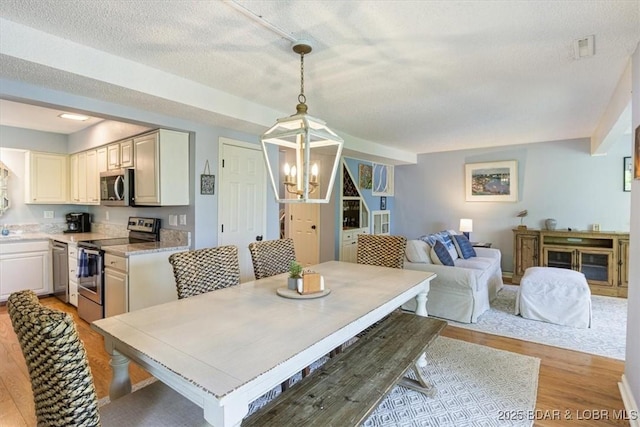 241 Shell Bay Cir Unit 1A, Linn Creek, MO 65052 - dining space featuring light wood finished floors and a chandelier