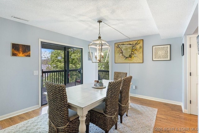 241 Shell Bay Cir Unit 1A, Linn Creek, MO 65052 - dining area featuring light wood-style floors, a textured ceiling, a chandelier, and baseboards