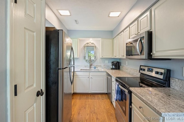 241 Shell Bay Cir Unit 1A, Linn Creek, MO 65052 - kitchen featuring appliances with stainless steel finishes, light wood-type flooring, and a sink