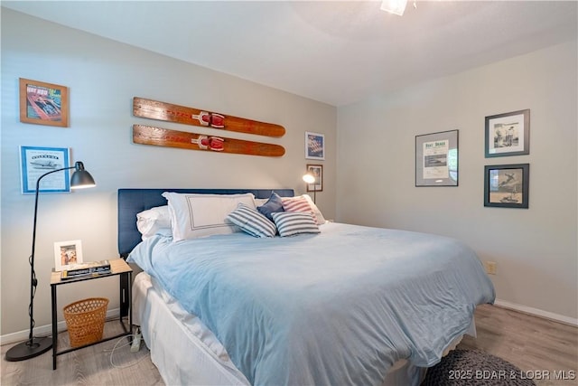bedroom featuring wood finished floors and baseboards