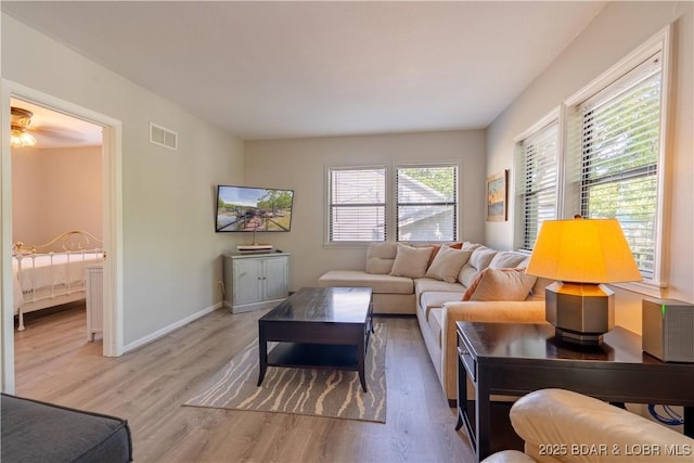 living area with light wood-type flooring and baseboards