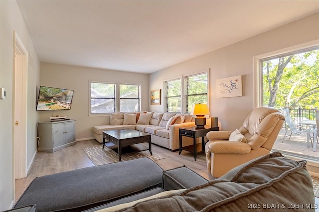 living area with light wood-type flooring and baseboards