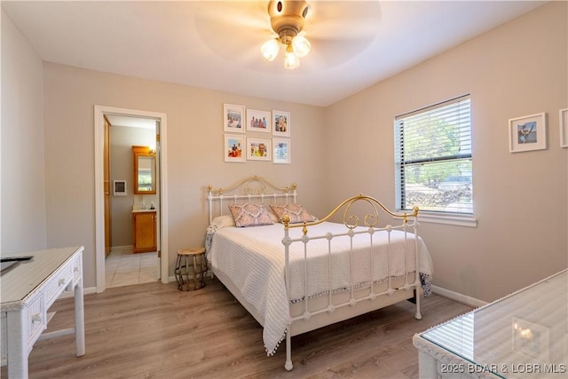 bedroom featuring light wood-style flooring, baseboards, and ensuite bathroom