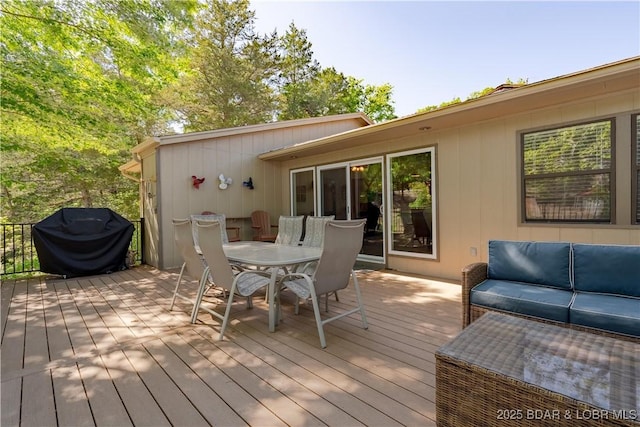 wooden terrace featuring area for grilling and outdoor dining area