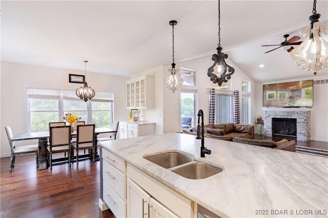 205 Wedge Wood Dr, Camdenton, MO 65020 - kitchen with a sink, a chandelier, a fireplace, dark wood-type flooring, and glass insert cabinets