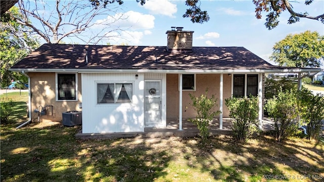 577 Mulberry Ln, Camdenton, MO 65020 - rear view of house featuring a chimney, central AC, and a yard