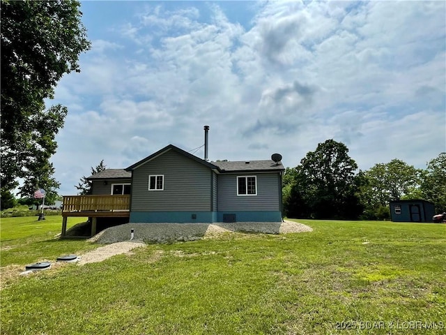 rear view of property with a wooden deck and a yard