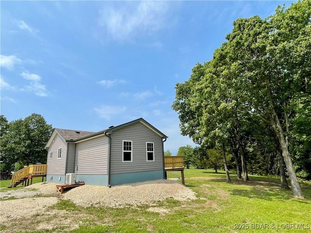 view of side of property with a lawn and a wooden deck