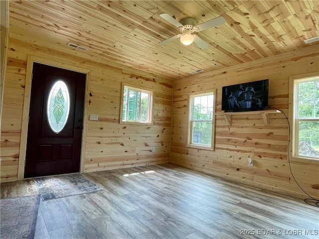 foyer entrance featuring wooden ceiling, plenty of natural light, wood walls, wood finished floors, and ceiling fan