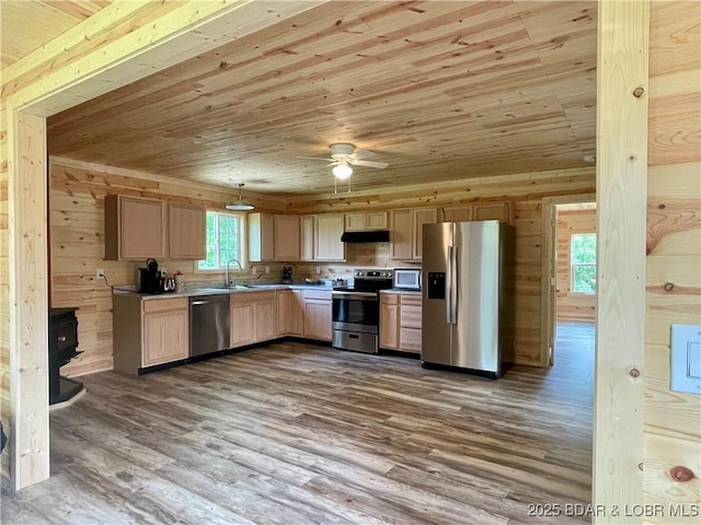 kitchen with appliances with stainless steel finishes, wooden ceiling, under cabinet range hood, dark wood finished floors, and wooden walls