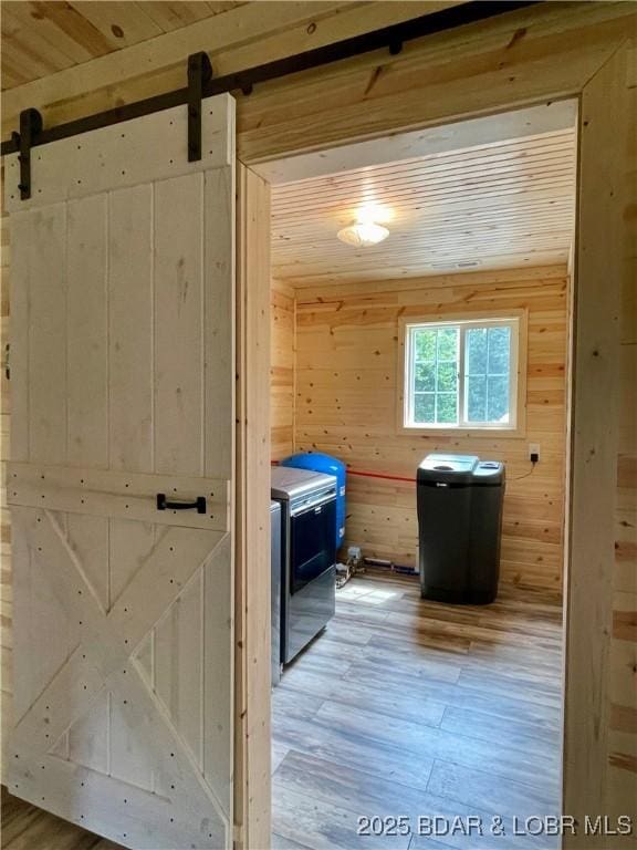 bathroom featuring wood finished floors, wooden walls, wooden ceiling, and washer and clothes dryer