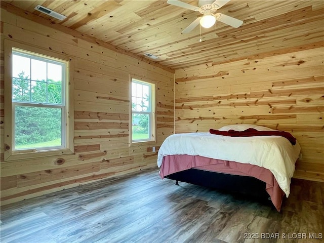 bedroom with wooden walls, wood finished floors, wooden ceiling, and ceiling fan