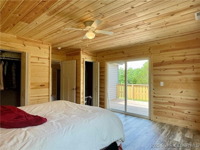 bedroom featuring wood ceiling, wooden walls, access to exterior, and wood finished floors