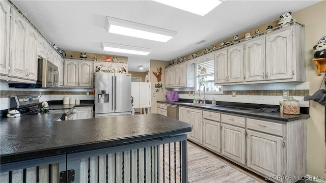 312 Charger Dr, Macks Creek, MO 65786 - kitchen featuring stainless steel appliances, dark countertops, a sink, and decorative backsplash