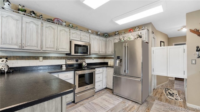 312 Charger Dr, Macks Creek, MO 65786 - kitchen with appliances with stainless steel finishes, dark countertops, and decorative backsplash