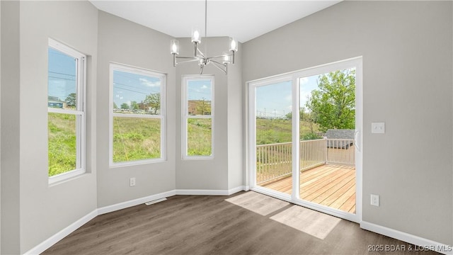 103 Primrose Ln, Camdenton, MO 65020 - unfurnished dining area with a chandelier, wood finished floors, and baseboards